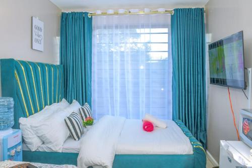 a bedroom with a bed with green curtains and a window at Luxe Oasis in Nairobi