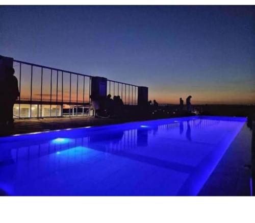 einem großen Pool mit blauer Beleuchtung vor einem Gebäude in der Unterkunft Luxe Oasis in Nairobi