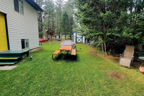 a picnic table in a yard next to a house at EVCharger, Free Parking, Ski, Golf, BBQ, Awesomeness in Invermere