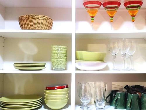 a shelf with wine glasses and plates and bowls at EVCharger, Free Parking, Ski, Golf, BBQ, Awesomeness in Invermere
