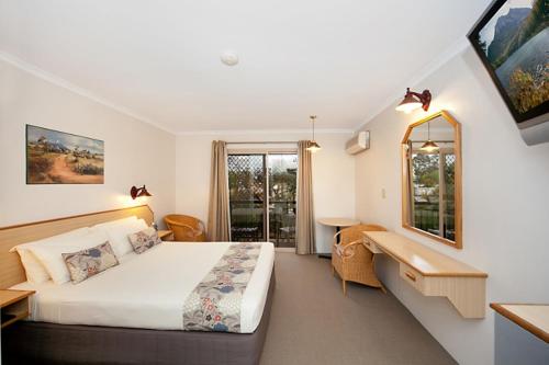 a hotel room with a bed and a mirror at Ingenia Holidays Taigum in Brisbane