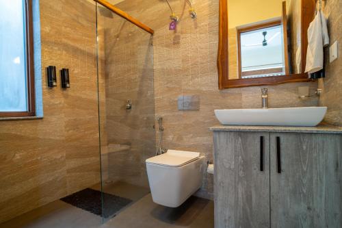 a bathroom with a toilet and a sink and a shower at SaffronStays Wood Sparrow in Bhīm Tāl
