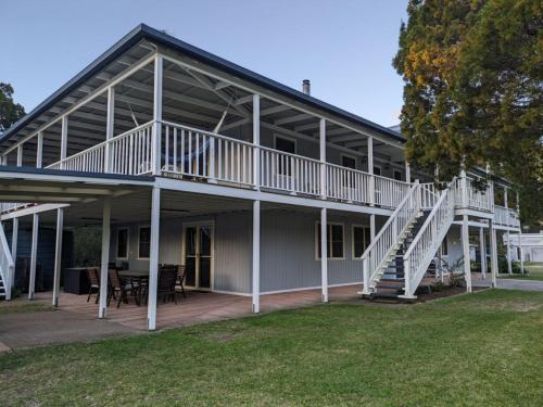 a large white house with a porch and stairs at Kiarabilli in Bulwer