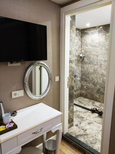 a bathroom with a shower with a television on the wall at Sun Comfort Hotel in Istanbul