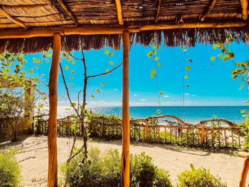 a view of the beach from a straw umbrella at VOVO TELO LODGE in Toliara