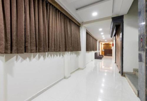 a hallway with brown curtains and a white floor at hotelbhavya in Ahmedabad