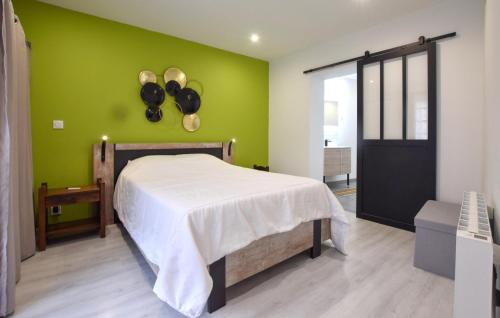 a bedroom with a bed and a green wall at Nice Home In Quettehou With Kitchen in Quettehou