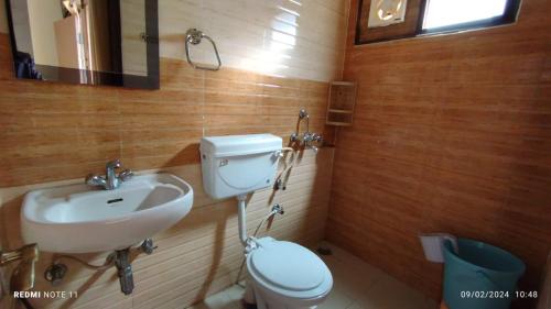 a bathroom with a toilet and a sink at Kainchi daam Road Nainital full 2bhk in Nainital