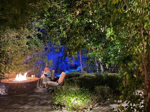 a woman sitting in a chair next to a fire pit at Lucille Palm Springs in Palm Springs