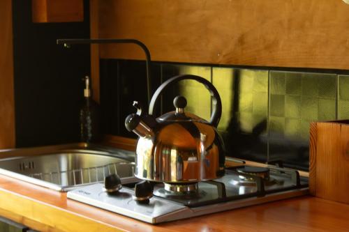 - Hervidor de té sobre una estufa en Refugios de bosque en Coñaripe, en Coñaripe