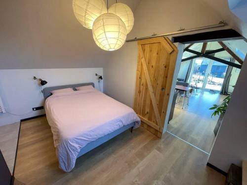 a bedroom with a bed and two chandeliers at Loft du presbytère - Calme et nature in Beauraing