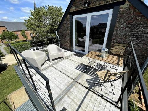 a patio with two chairs and a table at Loft du presbytère - Calme et nature in Beauraing