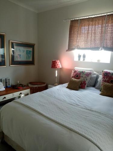 a bedroom with a large white bed with a window at Lor's Place in Mount Road