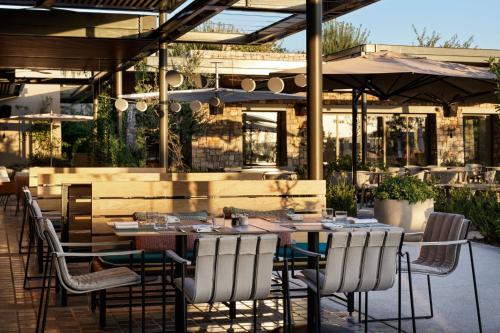 a restaurant with a table and chairs in front of a building at W Costa Navarino in Pylos
