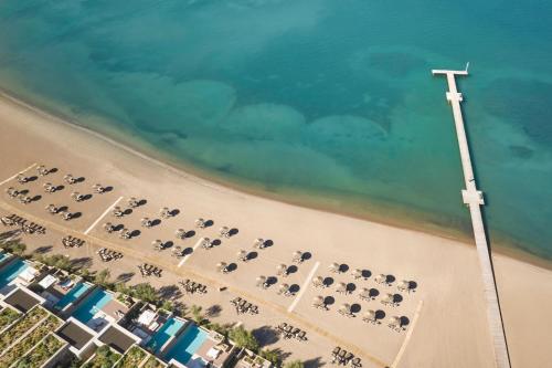 an overhead view of a beach with a row of chairs at W Costa Navarino in Pylos