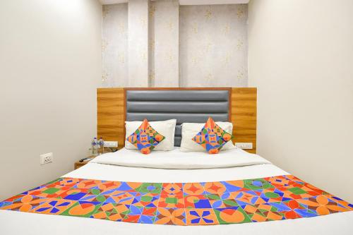 um quarto com uma cama com um edredão colorido em FabExpress Royal MG em Ludhiana