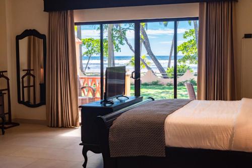 a bedroom with a bed and a view of the ocean at Sunset del Mar Beach Resort in Esterillos Este