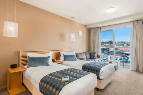 um quarto de hotel com duas camas e um sofá em Peppers Seaport Hotel em Launceston