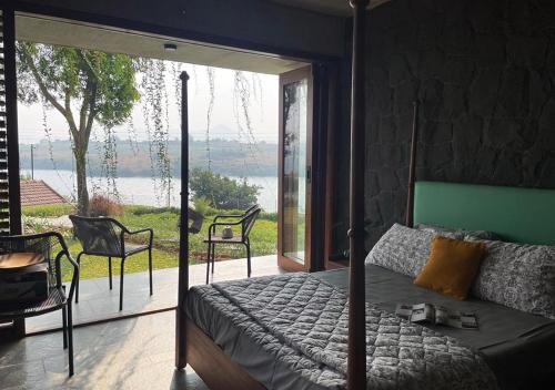 a bedroom with a bed with a view of the water at SaffronStays Avni in Trimbak