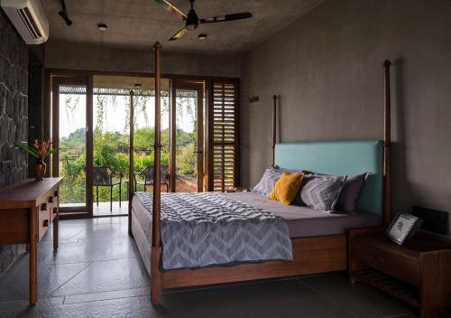特里姆巴克的住宿－SaffronStays Avni，一间卧室设有一张床和一个美景阳台