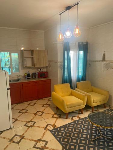 a kitchen with two yellow chairs and a table at Chambre Mamoudzou in Mamoudzou