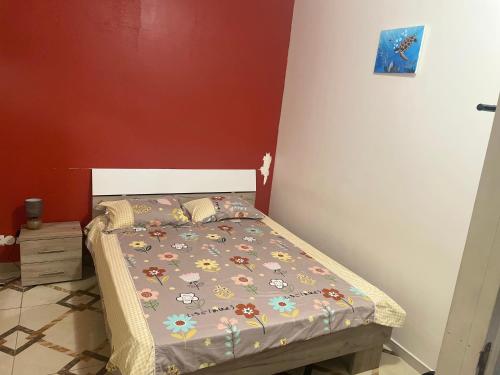 Un pequeño dormitorio con una cama con flores. en Chambre Mamoudzou, en Mamoudzou