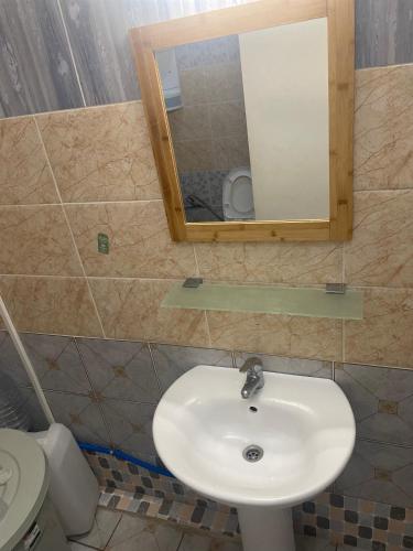 La salle de bains est pourvue d'un lavabo, d'un miroir et de toilettes. dans l'établissement Chambre Mamoudzou, à Mamoudzou