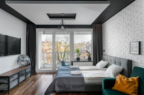 ein Schlafzimmer mit einem Bett und einem großen Fenster in der Unterkunft Apartaments 24 Premium Green in Breslau