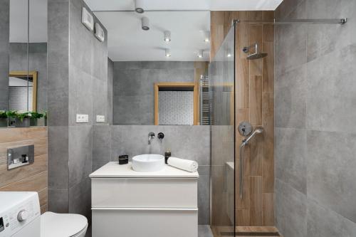 ein Bad mit einem WC, einem Waschbecken und einer Dusche in der Unterkunft Apartaments 24 Premium Green in Breslau