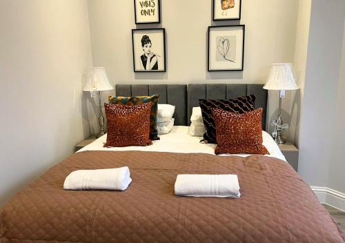 una camera da letto con un grande letto con due cuscini sopra di FW Haute Apartments at Enfield, Pet Friendly Ground Floor 3 Bedrooms and 2 Bathrooms Flat with King or Twin beds with Garden and FREE WIFI and FREE PARKING a Londra