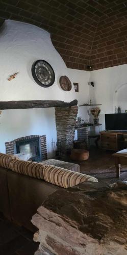a living room with a fireplace with a clock on the wall at Quinta da Belavista in Reguengos de Monsaraz