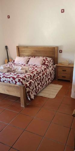 a bedroom with a large bed with a wooden headboard at Quinta da Belavista in Reguengos de Monsaraz