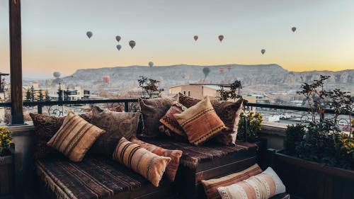 a couch sitting on top of a balcony with a view at Royal Stone Houses - Goreme in Göreme