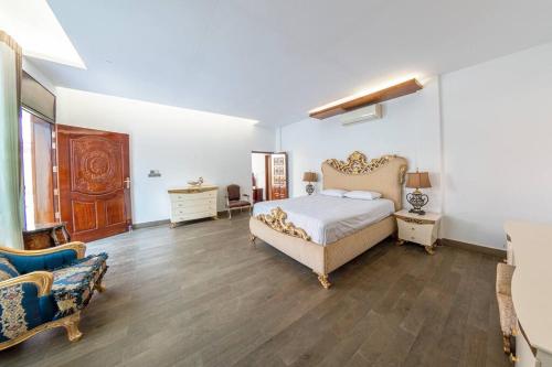 Grand Villa Oasis في داكا: غرفة نوم مع سرير مزدوج كبير وأريكة