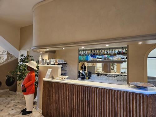 a woman standing at a bar in a restaurant at Hotel San Francisco in Viareggio