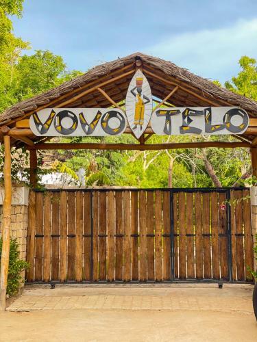 a gate with a wooden fence with a sign on it at VOVO TELO LODGE in Toliara