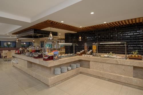 a restaurant with a counter with food on it at Delta Hotels by Marriott Dar es Salaam in Dar es Salaam