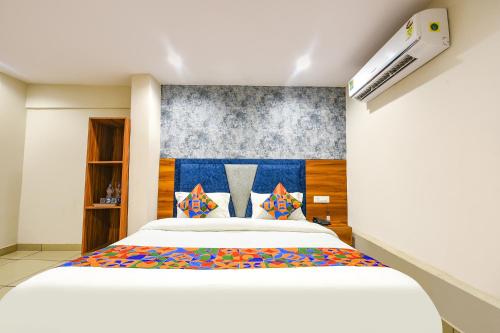 a bedroom with a large white bed with colorful pillows at FabHotel Orio I in Ludhiana