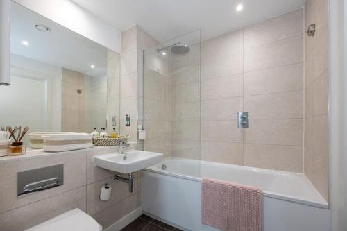 a bathroom with a tub and a sink and a bath tub at Flat close to Manchester Picadilly station in Manchester