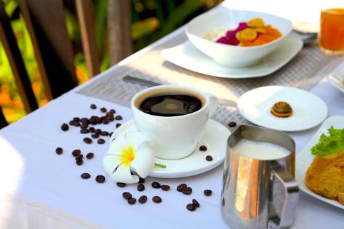 a cup of coffee and coffee beans on a table at Prana Hotel in Siem Reap