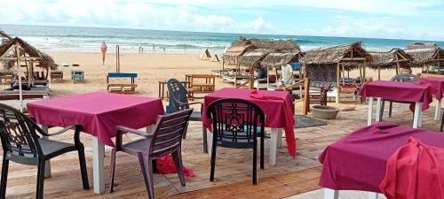 a group of tables and chairs on a beach at Hotel Universal Beach in Hikkaduwa