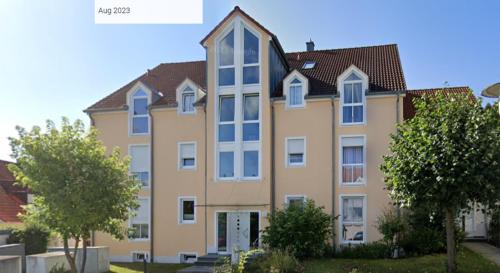 a large apartment building with trees in front of it at Schöne Gartenwohnung im Seenland in Wackersdorf