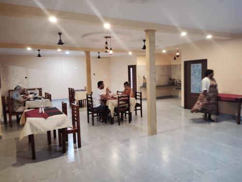 un groupe de personnes assises à table dans un restaurant dans l'établissement The Lake Paradise Boutique Resort, à Alappuzha