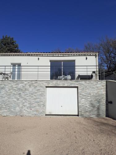 ein Gebäude mit zwei weißen Türen an der Seite in der Unterkunft Un coin de campagne in Le Puy-Sainte-Réparade