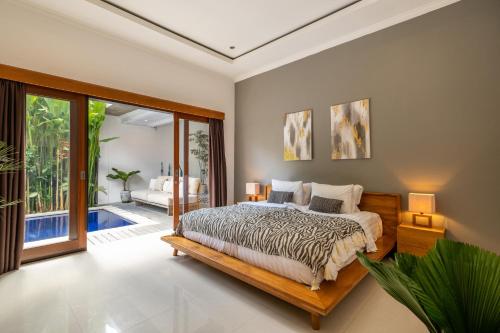 een slaapkamer met een bed en een glazen schuifdeur bij Villa Royal Canggu - 3 minutes to FINNS Beach club! in Canggu