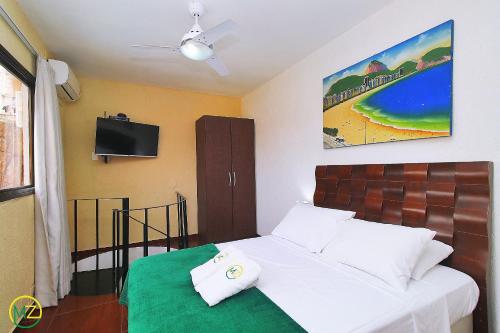 - une chambre avec un lit et une télévision murale dans l'établissement Amável cobertura duplex com piscina particular, à Rio de Janeiro