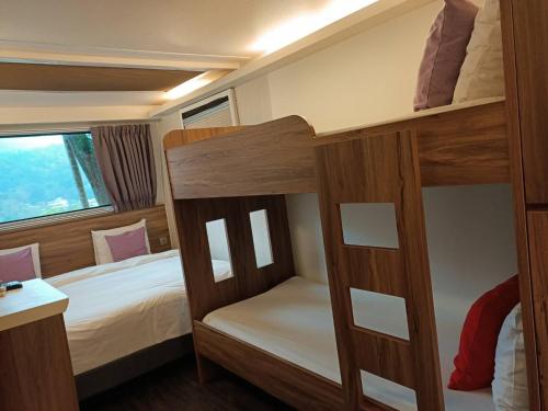 1 Schlafzimmer mit 2 Etagenbetten und einem Fenster in der Unterkunft Hula Garden in Shitan