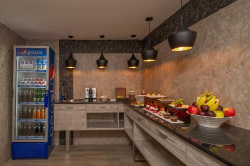 a kitchen with a counter with food and a refrigerator at Delta Hotels by Marriott Dar es Salaam in Dar es Salaam