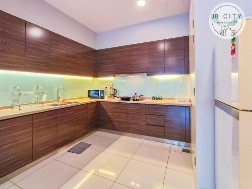 a kitchen with wooden cabinets and a sink at Puteri Harbour by JBcity Home in Nusajaya
