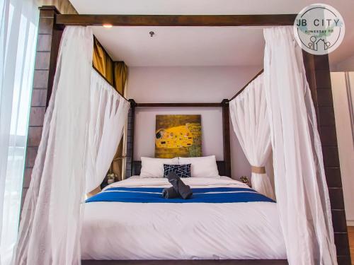 a bedroom with a canopy bed with white curtains at Puteri Harbour by RR JBcity in Nusajaya